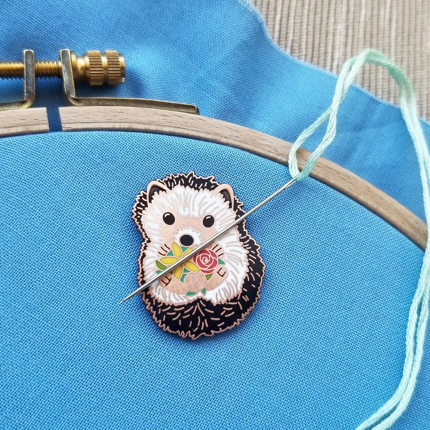 Embroidery hoop with a hedgehog design on blue fabric